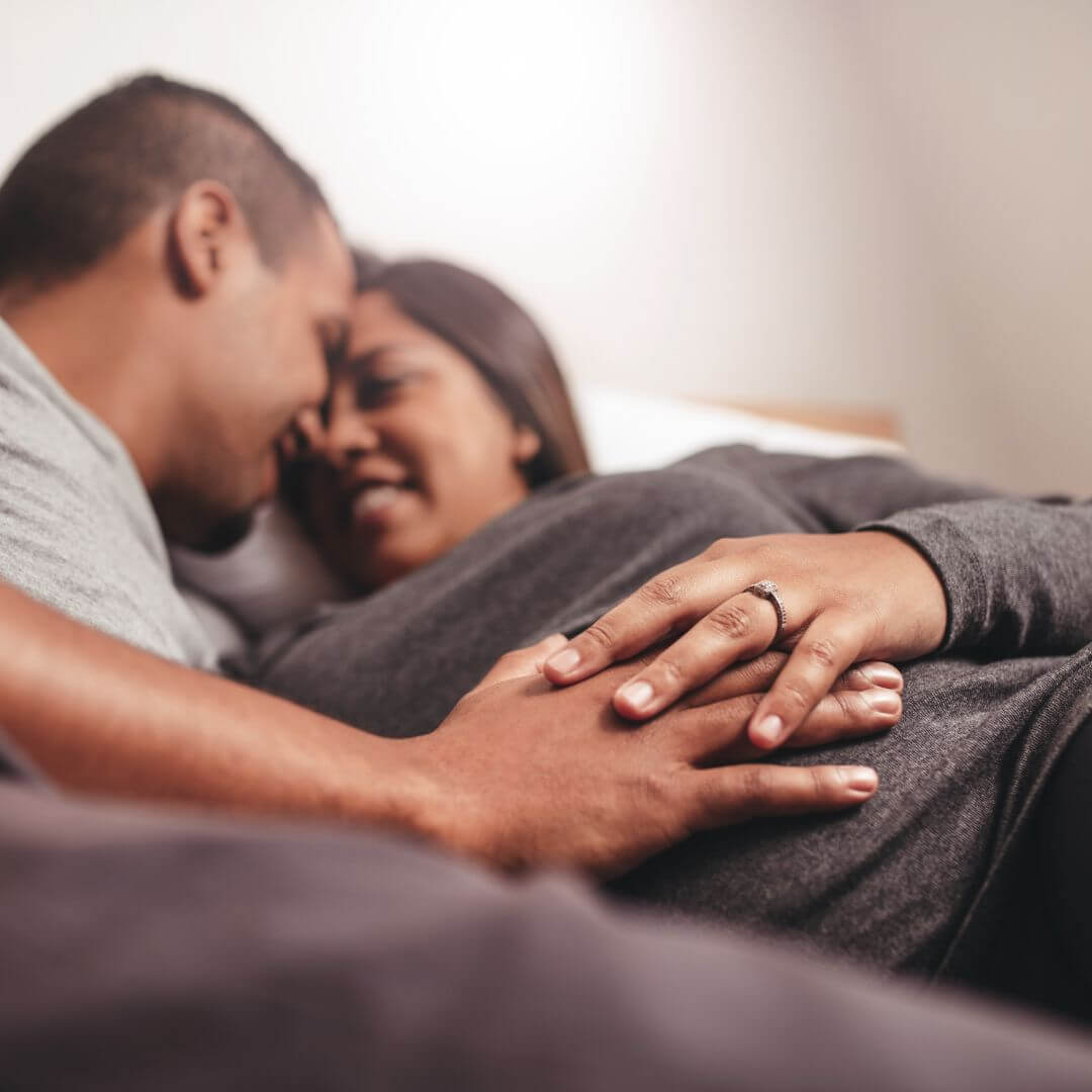 Couple avec mains sur le ventre